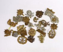 Twenty-five military cap badges including Gloucestershire Regiment, East Surrey, West Riding