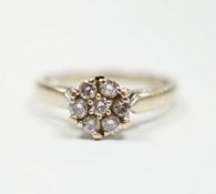A 750 white metal and seven stone diamond set circular cluster ring, size M, gross weight 3.2