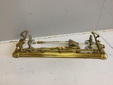 A Victorian Art Nouveau brass fender, length 136cm together with a set of three implements and a