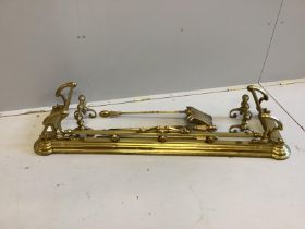 A Victorian Art Nouveau brass fender, length 136cm together with a set of three implements and a