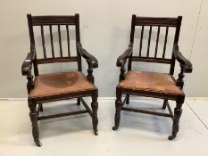 A pair of 1920's mahogany rail back elbow chairs, raised on castors, width 56cm, depth 47cm,