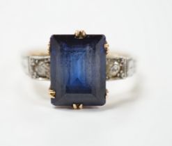 An 18ct, plat and single stone emerald cut synthetic? sapphire set dress ring with diamond set