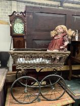 A Victorian style pram, width 80cm together with a modern bisque headed doll