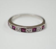 A modern 18ct white gold, ruby and diamond set half eternity ring, size O, gross weight 2.7 grams.