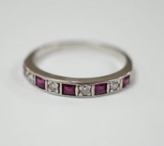 A modern 18ct white gold, ruby and diamond set half eternity ring, size O, gross weight 2.7 grams.