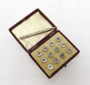 A boxed set of paste buttons and a silver pencil