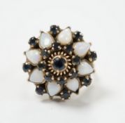 An 18k, white opal and sapphire set domed cluster dress ring, size O, gross weight 6.6 grams.