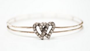 A late Victorian yellow metal and rose cut diamond set twin hearts bangle, gross weight 6.8 grams.