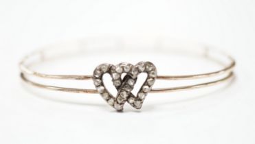 A late Victorian yellow metal and rose cut diamond set twin hearts bangle, gross weight 6.8 grams.