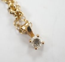 A modern 9ct gold and solitaire diamond set pendant, 9mm, on a 9ct chain, 38cm, gross weight 2.2