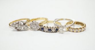 Four assorted 18ct and diamond set rings, including solitaire, flower head cluster, three stone