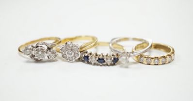 Four assorted 18ct and diamond set rings, including solitaire, flower head cluster, three stone