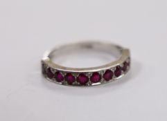 An 18ct white gold and eleven stone ruby set half eternity ring, size L, gross weight 3.8 grams.