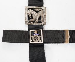 A black sash bracelet with diamond and enamel set Royal Fusiliers buckle, together with a similar