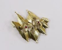 A 1960's 18ct gold, ruby and diamond set stylised foliate brooch, 45mm, gross weight 12.3 grams.