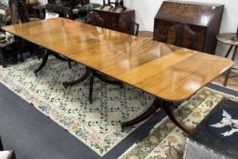 A George III style mahogany triple pillar extending dining table, 346cm extended, two spare
