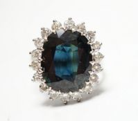 An 18ct, sapphire and diamond set oval cluster ring, size L, gross weight 5.7 grams.