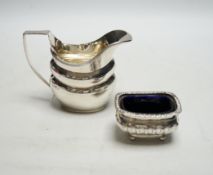 * * A George V silver helmet shaped cream jug and a silver salt with a gadrooned border. Please note
