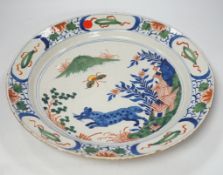 * * An 18th century delftware dish, the centre painted with a wolf, a bee and a pavilion, 35cm