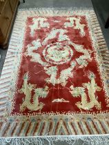 A 20th century Chinese silk 'dragon' rug, the red field woven with dragons within a cloud border,