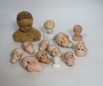 Twelve small bisque doll heads and a wax head
