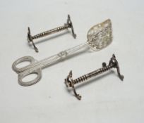 * * A pair of Swedish metal asparagus tongs and a pair of Edwardian silver knife rests, London,