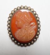 A Victorian yellow metal, and seed pearl mounted oval hardstone cameo pendant brooch, carved with