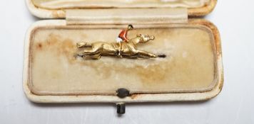 An Edwardian yellow metal, and polychrome enamelled novelty brooch, modelled as a horse with jockey,