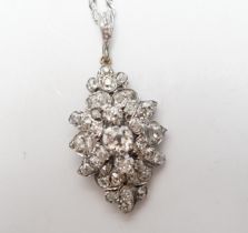 A white metal and diamond cluster set lozenge shape pendant, overall 38mm, on a modern 9ct white
