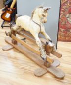 A Rocking horse on a wooden pedestal rocker, with plaster, composite body, height, 97cm, length