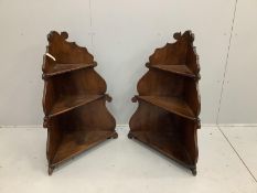A pair of 18th century style Italian walnut corner three tier wall brackets, width 70cm, depth 32cm,