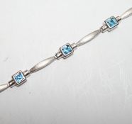 A modern brushed 9ct white gold and seven stone square cut blue topaz? set bracelet, 18cm, gross