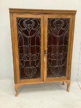A pair of Art Nouveau stained glass panels, now as an oak bookcase, width 104cm, depth 29cm,