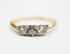 A yellow metal and three stone diamond set ring, size M, gross weight 2.3 grams.