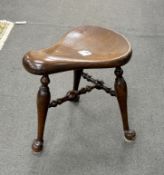 * * A George III style mahogany saddle seat three legged stool, width 41cm, depth 41cm, height