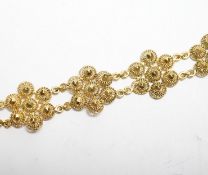 A yellow metal 'bright cut engraved' flower head link bracelet, 16cm, 14.7 grams.