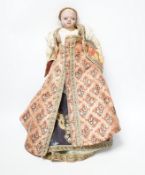 An early 19th century doll with a papier mache head, glass eyes and kid leather body, dressed in