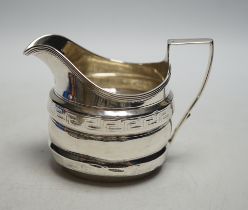 * * A George III silver helmet shaped cream jug, with engraved key pattern band, London 1804,