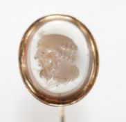 An early 20th century yellow metal and oval intaglio chalcedony set stick pin, 77mm.
