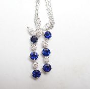 A modern 750 white metal, sapphire and diamond set cluster pendant, 31mm, on a twin strand white