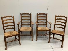 A set of four oak rush seat ladder back dining chairs, two with arms