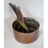 A copper two handled jam pan and a graduated set of eight copper saucepans