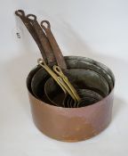 A copper two handled jam pan and a graduated set of eight copper saucepans