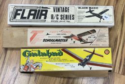 Three large wooden aircraft kits; a Flair Black Magic, a Top Flight Schoolmaster and a Mercury