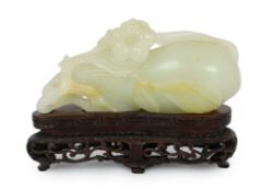 * * A Chinese pale celadon jade carving of a fruit, 18th century, with stalks and leaves, a flower