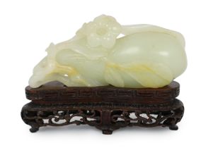 * * A Chinese pale celadon jade carving of a fruit, 18th century, with stalks and leaves, a flower