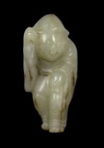 * A Chinese white jade figure of a boy wearing a hat and long coat, Ming dynasty, the stone with