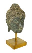 * A bronze head of Buddha, Northern Thailand, 14th century, on a stand, 13cm, (20cm overall)