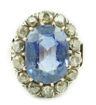 A Victorian gold, sapphire and diamond set oval cluster ring, the sapphire measuring approximately