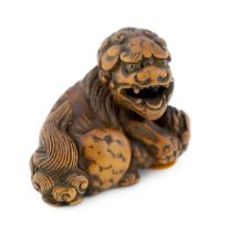 * A Japanese carved wood netsuke of a recumbent Shi-Shi, signed Toyomasa?, late 18th century, with